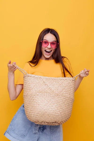 Genç, güzel kadın saman çanta duyguları yaz tarzı sarı arka plan