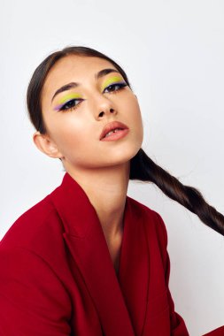 Güzel esmer, parlak makyajlı, kırmızı ceketli. Stüdyo modelini değiştirmemiş.