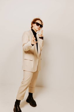 Takım elbiseli neşeli kadın elleri ile jest yapar. Duyguları değişmez.