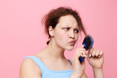 Mavi tişörtlü bir kadının portresi. Saçı kıllı taraklı. Geçmişi değiştirilmemiş.