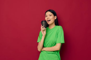 Çekici genç Asyalı kadın yeşil tişörtlü, tek kullanımlık siyah gözlüklü stüdyo modeli ile poz veriyor.