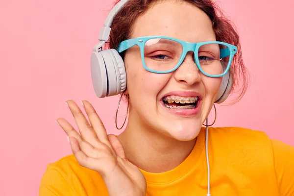 Schöne Frau gelb T-Shirt Kopfhörer Unterhaltung Musik Spaß rosa Hintergrund unverändert — Stockfoto