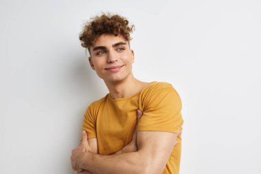 Yakışıklı genç adam stüdyo tebessümü takınıyor.