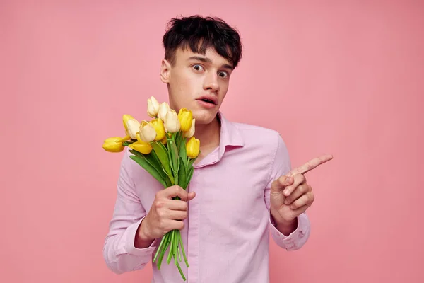 Молодий чоловік Букет жовтих квітів романтика позує модний рожевий фон незмінним — стокове фото