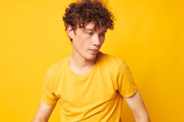 Genç, kıvırcık bir adamın portresi. Gençlik stili. Stüdyo kıyafetleri.