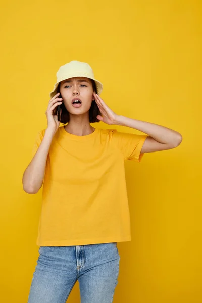 Vacker flicka i en gul hatt Ungdom stil avslappnad prata på telefonen isolerad bakgrund — Stockfoto