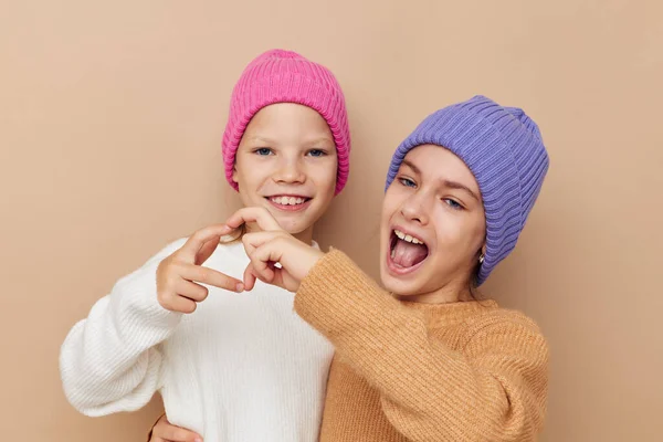 Twee grappige kleine meisjes in kleurrijke hoeden — Stockfoto