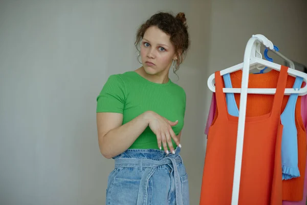 Hermosa mujer planchando ropa en un armario percha fondos aislados inalterados —  Fotos de Stock