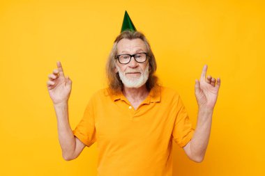 Yaşlıların portresi. Eğlenceli bir doğum günü şapkası. Kafasında izole bir arka plan.