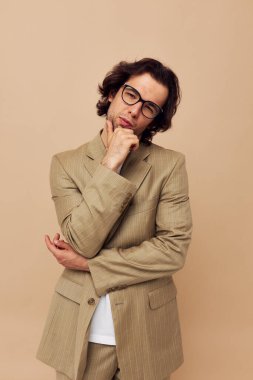 Neşeli adam gözlüklü bej takım elbise şık bej arka plan