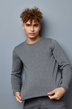 Gri kazaklı yakışıklı adam. Moda stüdyosu. Yaşam tarzı değişmemiş.