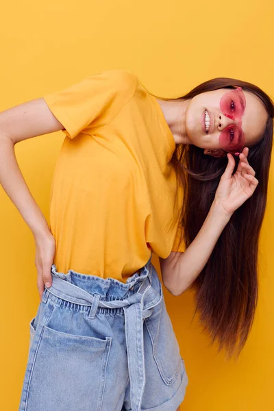 Όμορφη μόδα κορίτσι σε κίτρινο t-shirt denim σορτς απομονωμένο φόντο — Φωτογραφία Αρχείου