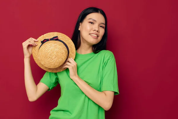 Retrato Asiático bela jovem mulher sorriso verde t-shirt chapéu posando moda vermelho fundo inalterado — Fotografia de Stock