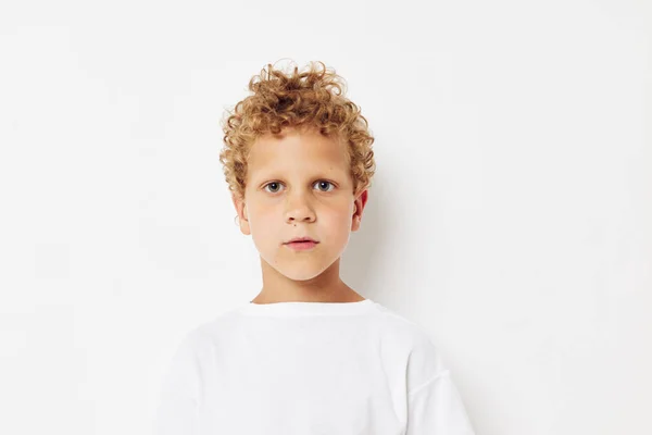 Emocjonalny chłopiec z kręconymi włosami w białym t-shircie zbliżenie — Zdjęcie stockowe
