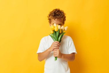 Bir buket sarı çiçekli sevimli çocuk. Arka planı değiştirilmemiş.