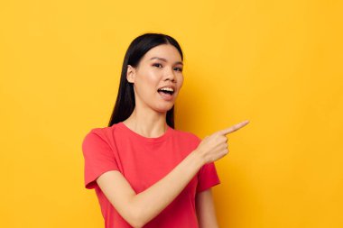 Güzel esmer kırmızı tişörtler modern stil stüdyo modelini değiştirmeden poz veriyor.