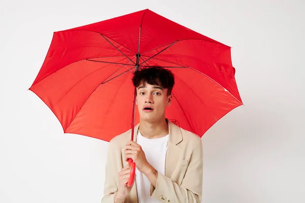 A young man red umbrella a man in a light jacket isolated background unaltered — Stock Fotó