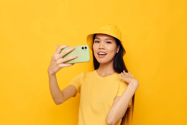 Donna con aspetto asiatico parlando al telefono posa moda giallo sfondo inalterato — Foto Stock