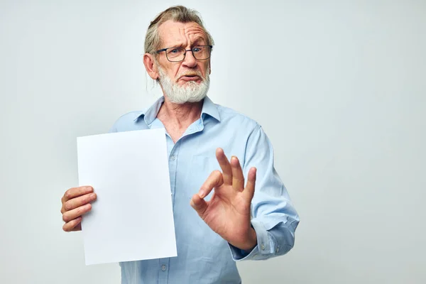 Пожилой человек держит лист бумажного копировального пространства, представляющий собой изолированный фон — стоковое фото