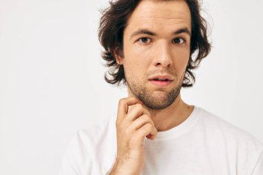 Beyaz tişörtlü çekici bir adam. El hareketi. Yaşam tarzı değişmemiş.