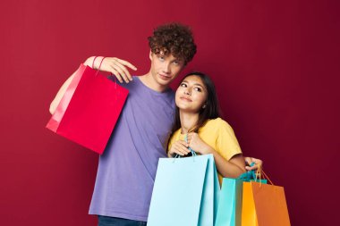 Genç erkek ve kız renkli çantalar alışveriş eğlenceli yaşam tarzı değiştirilmemiş