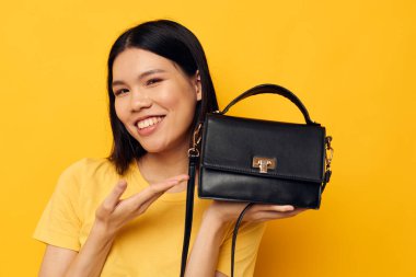 gülümseyen Asyalı kadın çantası moda sarı arka plan