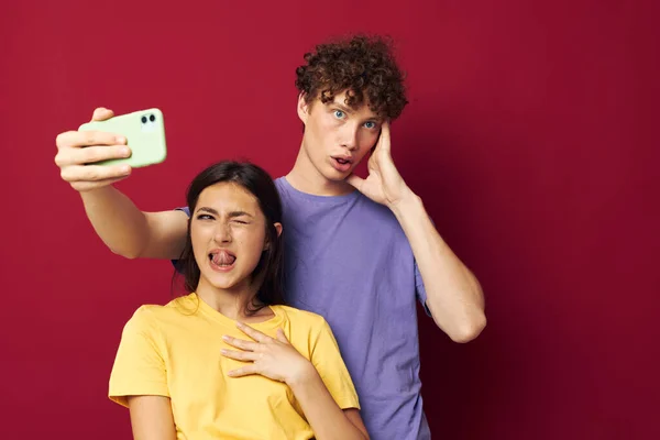 Giovane uomo e ragazza in t-shirt colorate con un telefono Stile giovanile — Foto Stock