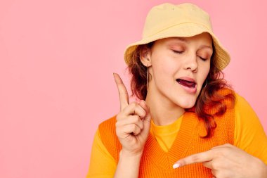 Komik kız, ekşi küpeler. Şapka takıyor. Arka planda bir değişiklik yok.