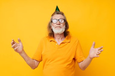 Yaşlıların portresi. Eğlenceli bir doğum günü şapkası. Kafasında izole bir arka plan.