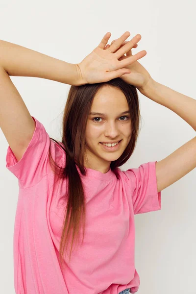 Pozitív nő egy rózsaszín póló alkalmi ruhák rózsaszín háttér — Stock Fotó
