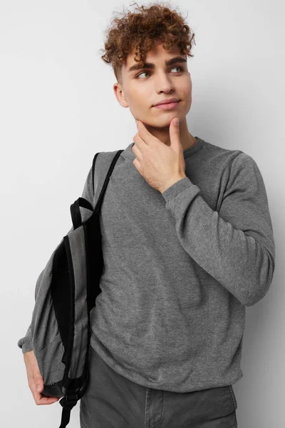 Handsome guy in a gray sweater backpack fashion isolated background — 图库照片