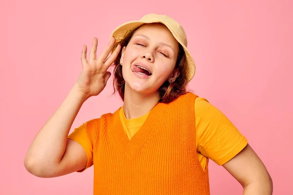 Grappig meisje in een oranje trui in gele hoed hand gebaar bijgesneden uitzicht ongewijzigd — Stockfoto