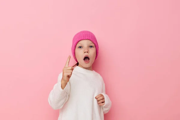 Little girl pink hat on her head posing pink background — Stock fotografie