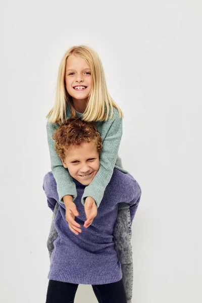 两个穿着彩色毛衣的孩子摆出一副童年时代未变的样子的照片 — 图库照片
