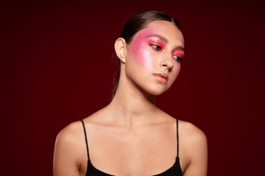 Genç, güzel bir kadın lüks kozmetik ürünleri sergileyen el kol hareketleri yapıyor. Geçmişi değiştirilmemiş.