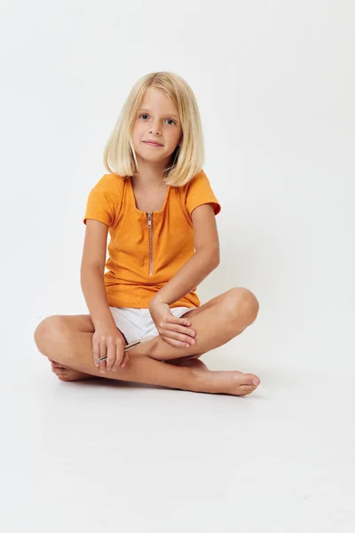 Aranyos lány szőke haj ül a padlón — Stock Fotó