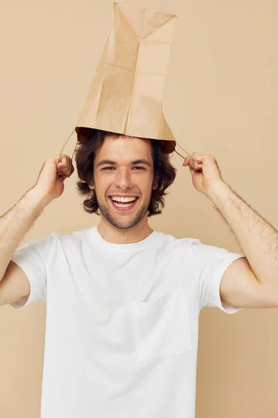 Attractive man in a white T-shirt with paper bag Lifestyle unaltered — Stockfoto