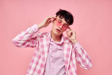 Romantik genç erkek arkadaşın fotoğrafı. Moda pembe güneş gözlüğü ceketi. Yaşam tarzını değiştirmeden poz veriyor.