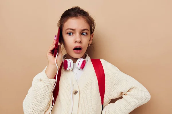 Κορίτσι με σακίδιο πλάτης σε ακουστικά με τεχνολογία τηλεφώνου — Φωτογραφία Αρχείου