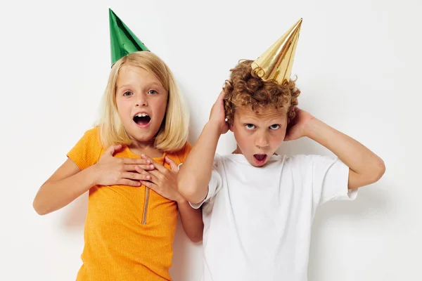 Lindos niños elegantes en casquillos multicolores cumpleaños fiesta emoción aislado fondo inalterado —  Fotos de Stock