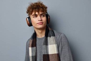 Sapık adam, ekose eşarp kablosuz kulaklık teknolojisi izole edilmiş arka plan.
