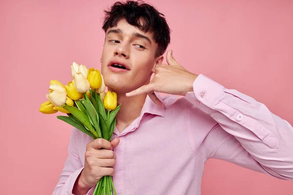 Молодий чоловік Букет жовтих квітів романтика позує модний рожевий фон незмінним — стокове фото
