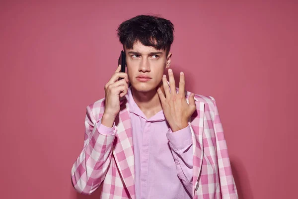 Foto de novio joven romántico con un teléfono en la mano chaqueta rosa moda estilo elegante Estilo de vida inalterado — Foto de Stock