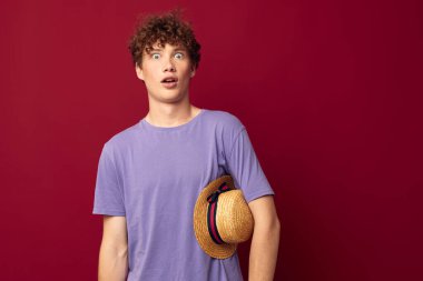 Genç adam gündelik kıyafetlerle kızıl saçlı. Gençlik stili, kırmızı arka plan değiştirilmemiş.