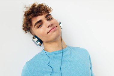 Mavi tişörtlü yakışıklı adam kulaklıklı moda arkaplanı.