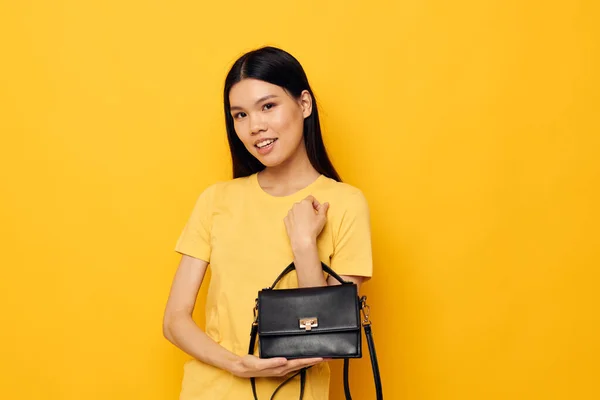 Porträtt Asiatiska vackra unga kvinna i gula t-shirts mode poserar kvinnliga tillbehör Monokrom skott — Stockfoto