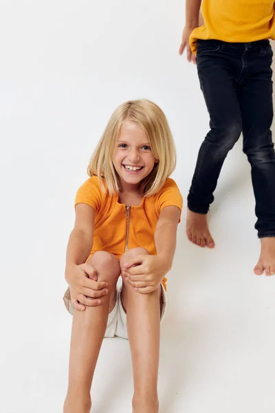 Sarı tişörtlü şirin çocuk ve kız çocukluk eğlence stüdyosu — Stok fotoğraf