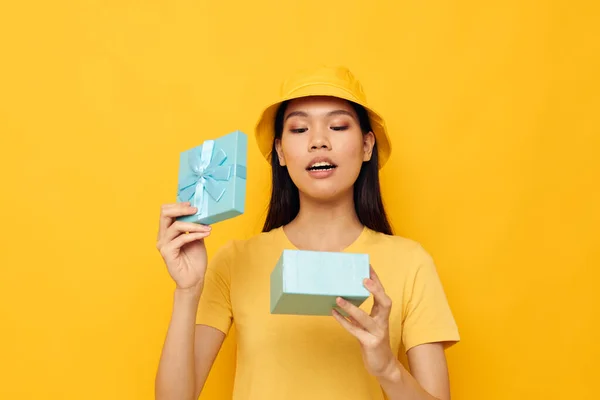 Woman in a yellow T-shirt and a hat with a gift studio model unaltered — Stock Photo, Image
