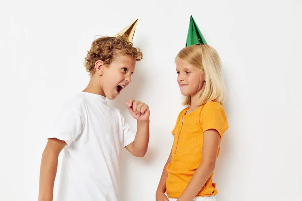 Crianças alegres com bonés em sua cabeça férias entretenimento isolado fundo inalterado — Fotografia de Stock