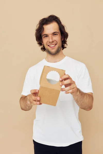 Веселий чоловік у білій футболці з картонною коробкою в руках — стокове фото